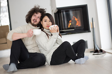 Image showing happy multiethnic couple  in front of fireplace