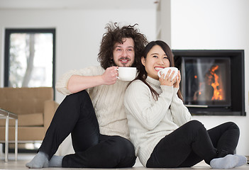 Image showing happy multiethnic couple  in front of fireplace