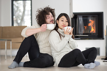 Image showing happy multiethnic couple  in front of fireplace