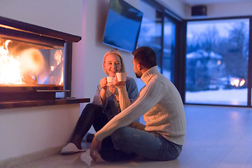 Image showing happy couple in front of fireplace