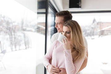 Image showing young couple enjoying morning coffee by the window