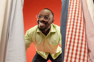 Image showing Handsome man with beard choosing shirt in a shop