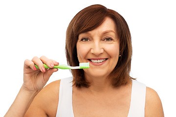 Image showing senior woman with toothbrush brushing her teeth