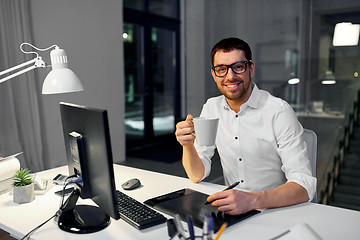 Image showing designer with pen tablet drinking coffee at office