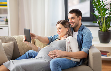 Image showing man and pregnant woman with tablet pc at home