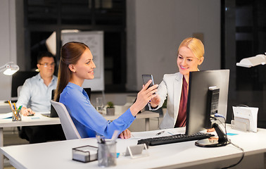 Image showing businesswomen with smartphone late at night office