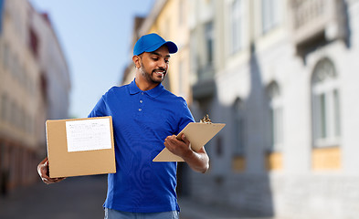 Image showing delivery man with parcel and clipboard in city