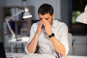 Image showing tired businessman working at night office