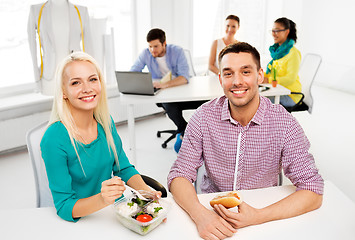 Image showing happy colleagues having lunch and eating at office