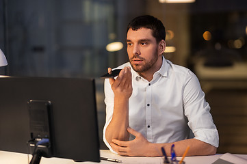 Image showing businessman recording voice message on smartphone