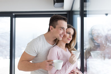 Image showing young couple enjoying morning coffee by the window