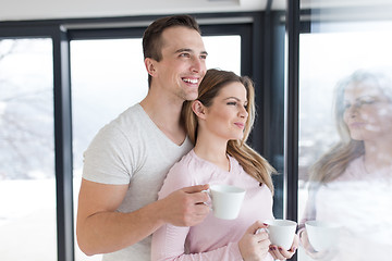 Image showing young couple enjoying morning coffee by the window