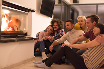 Image showing multiethnic couples sitting in front of fireplace