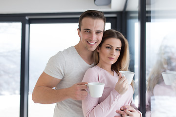 Image showing young couple enjoying morning coffee by the window