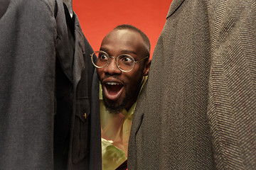 Image showing Handsome man with beard choosing shirt in a shop