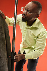 Image showing Handsome man with beard choosing shirt in a shop