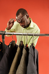 Image showing Handsome man with beard choosing shirt in a shop