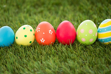 Image showing row of colored easter eggs on artificial grass