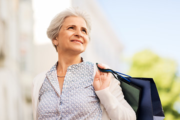 Image showing senior woman with shopping bags in city