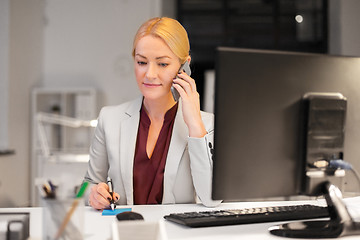 Image showing businesswoman calling on sartphone at night office