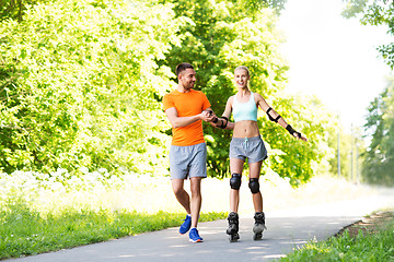 Image showing couple with roller skates riding in summer park
