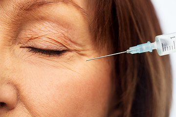 Image showing close up of senior woman face and syringe