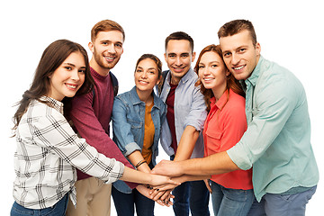 Image showing group of smiling friends stacking hands