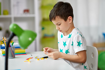 Image showing little boy playing with building kit at home