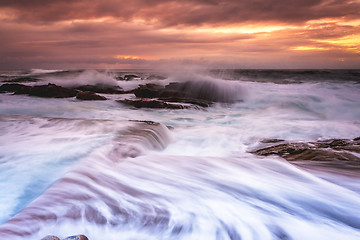 Image showing Large waves wash into the tidal ocean pool at sunrise