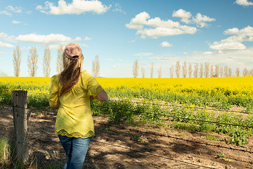 Image showing Female admiring the rural fields of canola in flower during spri
