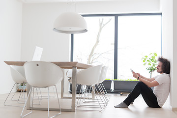 Image showing young man using a tablet at home