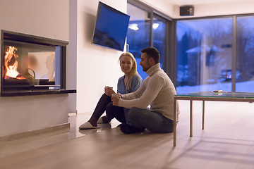 Image showing happy couple in front of fireplace