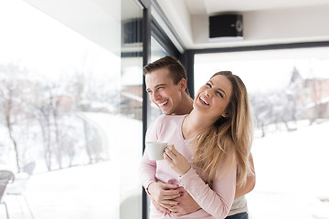 Image showing young couple enjoying morning coffee by the window