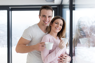 Image showing young couple enjoying morning coffee by the window