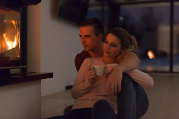 Image showing happy couple in front of fireplace