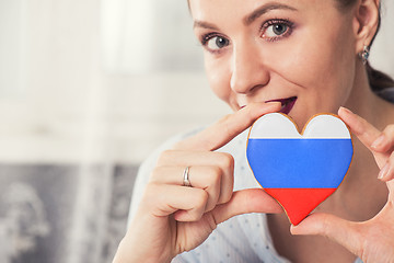 Image showing Young woman with gingerbread heart cookies with flag