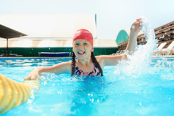Image showing The portrait of happy smiling beautiful teen girl at the pool