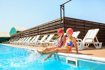 Image showing The portrait of happy smiling beautiful teen girls at the pool