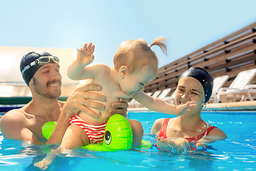 Image showing Happy family having fun by the swimming pool