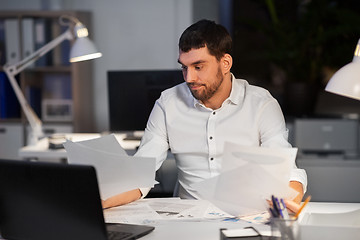 Image showing businessman with papers working at night office