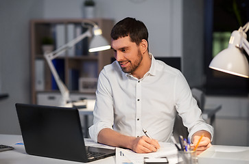 Image showing businessman with laptop working at night office