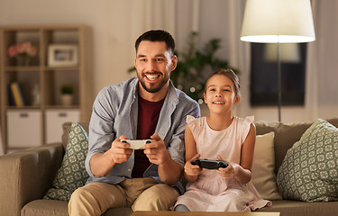 Image showing father and daughter playing video game at home