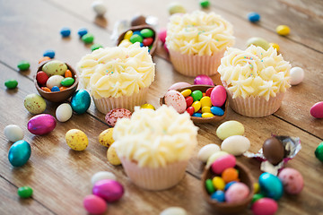 Image showing cupcakes with easter eggs and candies on table