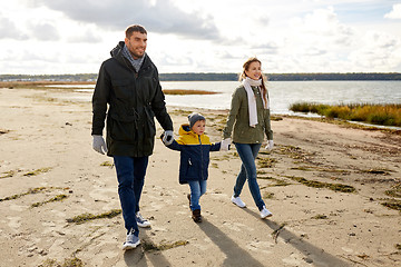 Image showing happy family walking along autumn beach