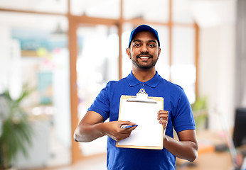 Image showing happy indian delivery man with clipboard at office