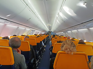 Image showing People are sitting in an airplane cabin during flight