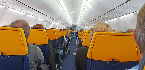 Image showing People are sitting in an airplane cabin during flight