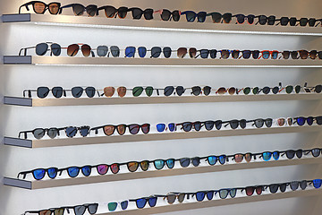 Image showing Lot of sunglasses on the wall showcase