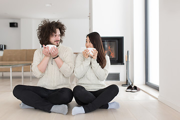 Image showing happy multiethnic couple  in front of fireplace