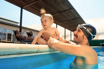 Image showing Happy family having fun by the swimming pool